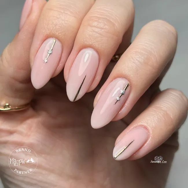 Minimal nude nails with fine metallic lines and gems